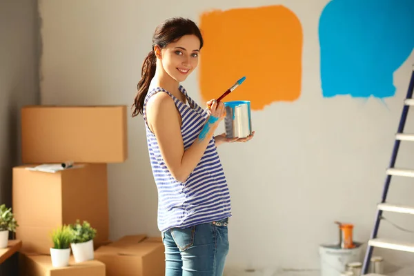 Šťastný usmívající se žena malování vnitřní stěny nového domu — Stock fotografie