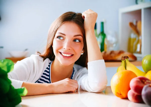 Young woman standing near desk in the kitchen Stock Image