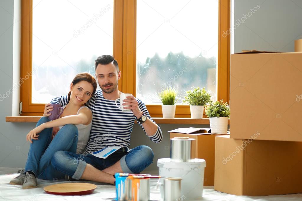 Couple moving in house sitting on the floor