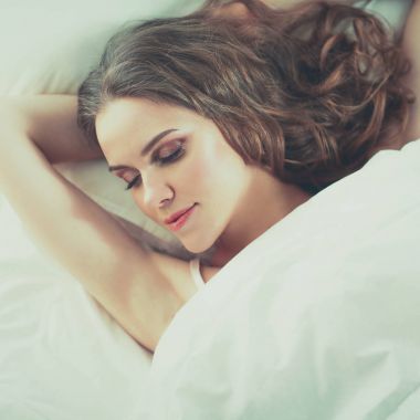 Güzel bir kadın yatağında uzanıyor.
