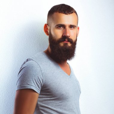 Ayakta, gri arka plan üzerinde izole yakışıklı adam portresi