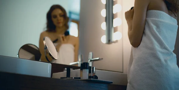Giovane donna guardarsi allo specchio in bagno — Foto Stock