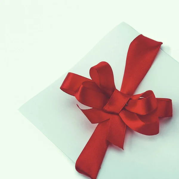 Close up of card note with red ribbon on white background — Stock Photo, Image