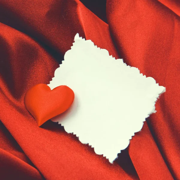 Czerwone serce i puste białe kartki pocztowe, leżącego na jedwabiu — Zdjęcie stockowe