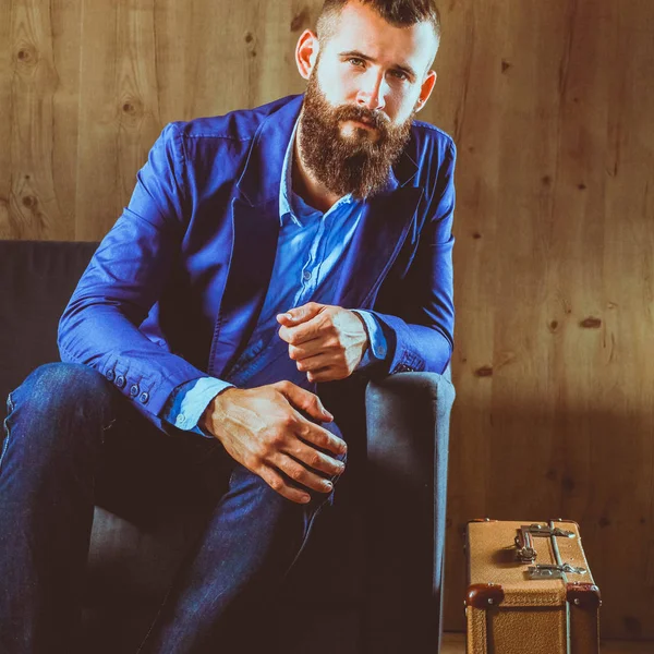 Businessman sitting the sofa in office lobby, isolated on dark background — Stock Photo, Image