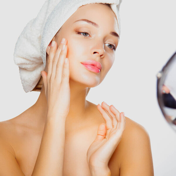 Portrait of beautiful girl touching her face with a towel on head