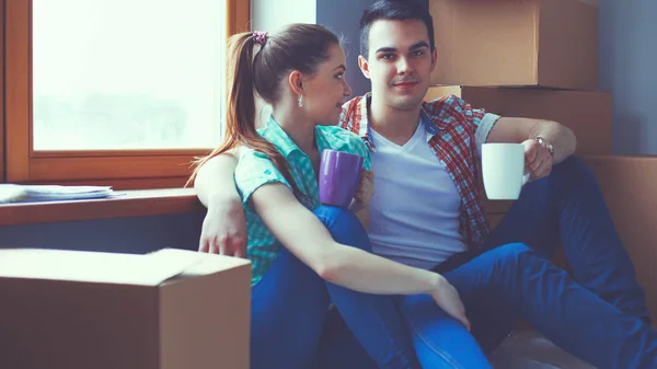 Couple moving in house sitting on the floor