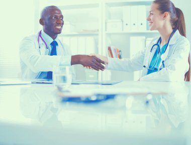 Ofiste tokalaşırken gülümseyen iki genç doktor.
