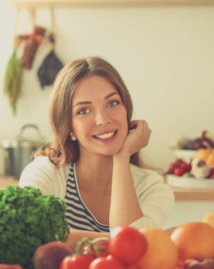 Genç bayan mutfakta masanın yanında oturuyor.