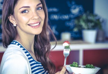 Salata yemek ve karışık salata tutan genç kadın
