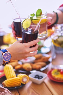 Yemek masasında içki içen insanlar.