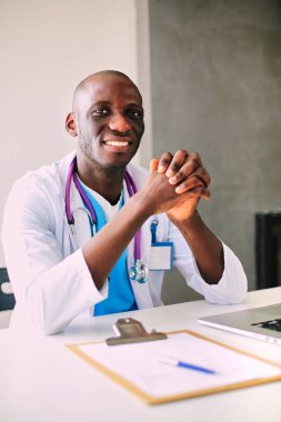 Masada dizüstü bilgisayarda çalışan genç bir Afrikalı doktor.
