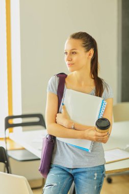 Egzersiz kitap tutan bir genç öğrenci kadın portresi.