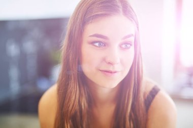 Güzel bir kadın mutfakta pasta pişiriyor. Masanın yanında duruyor.