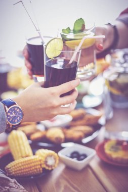 Yemek masasında içki içen insanlar.