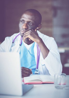 Masada dizüstü bilgisayarda çalışan genç bir Afrikalı doktor.