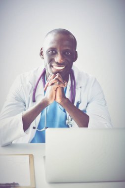 Masada dizüstü bilgisayarda çalışan genç bir Afrikalı doktor.