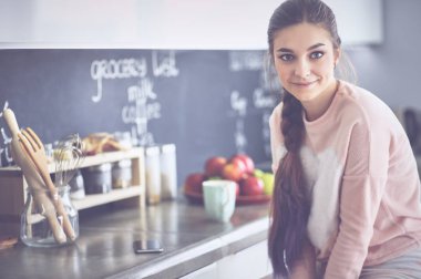 Mutfak tablosunda yakın oturan genç kadın