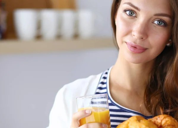 Ung kvinna med ett glas juice och kakor — Stockfoto