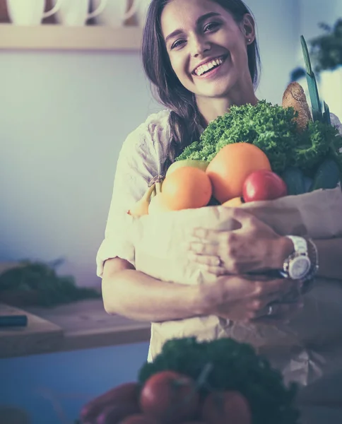 Young woman holding grocery shopping bag with vegetables and fruit — Stock Photo, Image