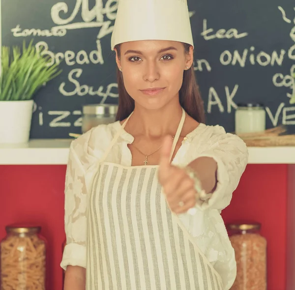 Chef woman portrait with  uniform in the kitchen and showing ok