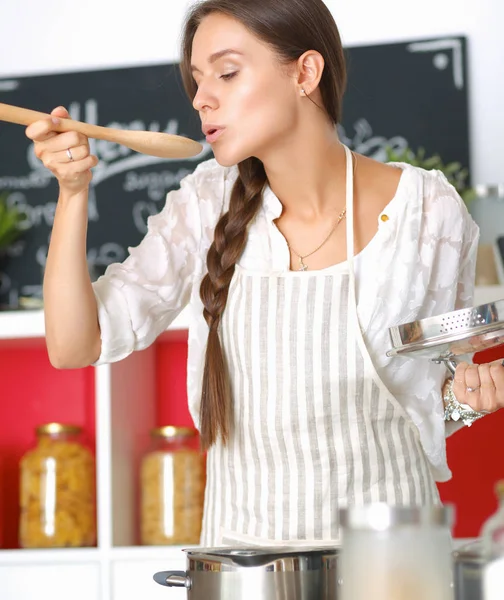 Mujer cocinera en cocina con cuchara de madera —  Fotos de Stock