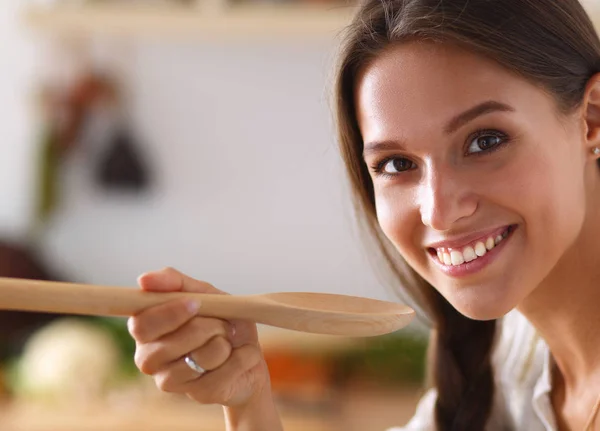 Cucina donna in cucina con cucchiaio di legno — Foto Stock