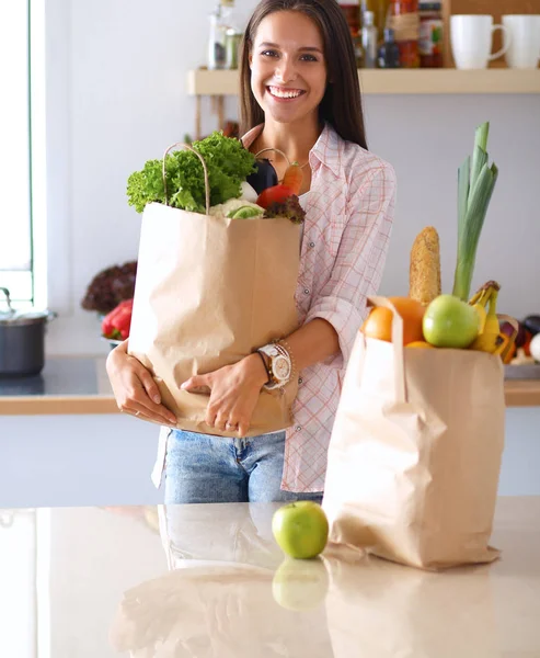 野菜と食料品の買い物袋を持っている若い女性 — ストック写真