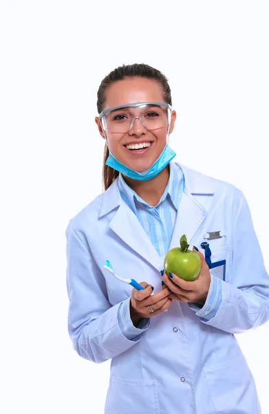 Fogorvos orvos nő tartsa zöld friss alma a kezében és fogkefe — Stock Fotó
