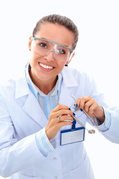 A young dentist with a tool on a white background — Stock Photo, Image