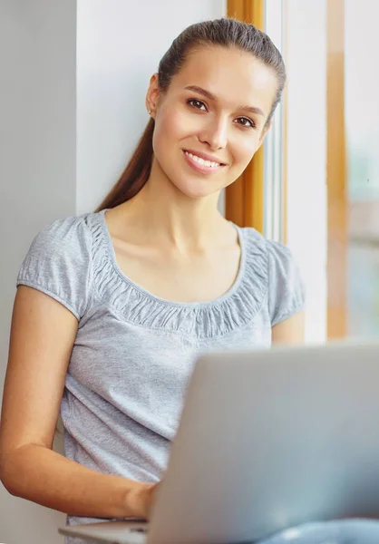 Jeune belle femme en utilisant un ordinateur portable à la maison — Photo