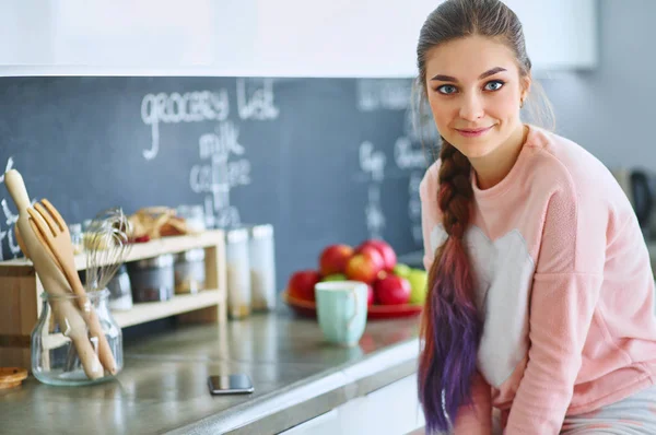 Young woman sitting near table in the kitchen — Stock Photo, Image