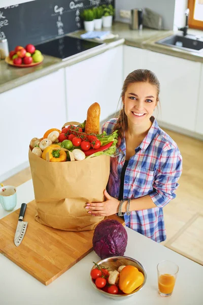 Young woman holding grocery shopping bag with vegetables — Stock Photo, Image