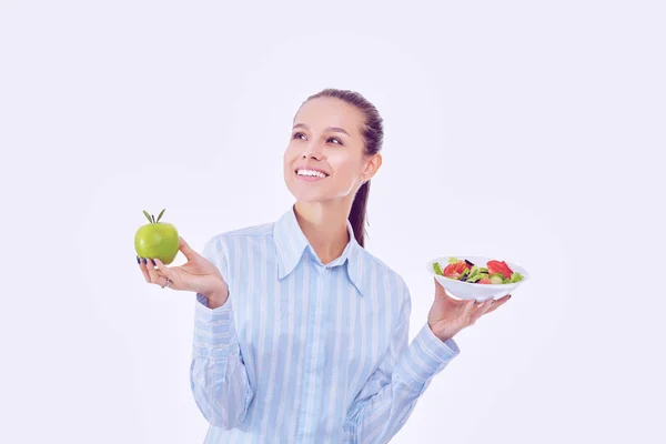 Retrato de una hermosa doctora sosteniendo un plato con verduras frescas y manzana verde — Foto de Stock