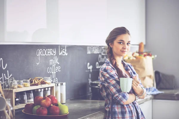 Gelukkige vrouw het drinken van thee in de keuken thuis — Stockfoto