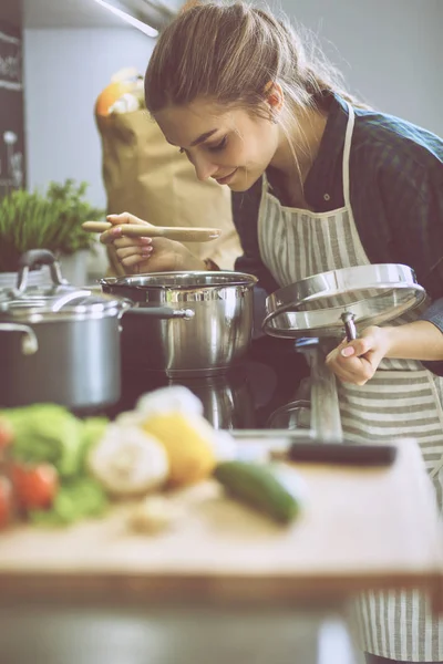 Junge Frau kocht in ihrer Küche am Herd — Stockfoto