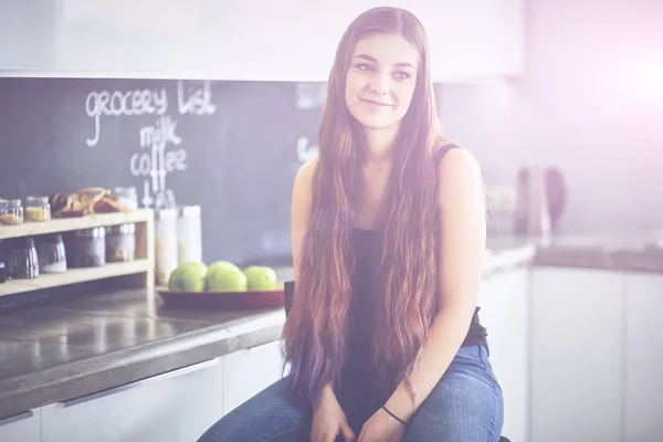 Hermosa mujer cocinando pastel en la cocina de pie cerca del escritorio —  Fotos de Stock