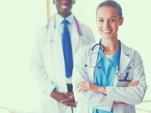 Une femme médecin souriante avec un dossier en uniforme à l'intérieur — Photo
