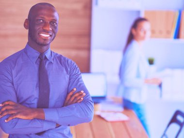 İş kadını ofisinde tablet bilgisayar kullanarak oturuyor.