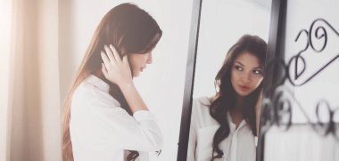 Genç kadın kendini evde aynada yansıma arıyor