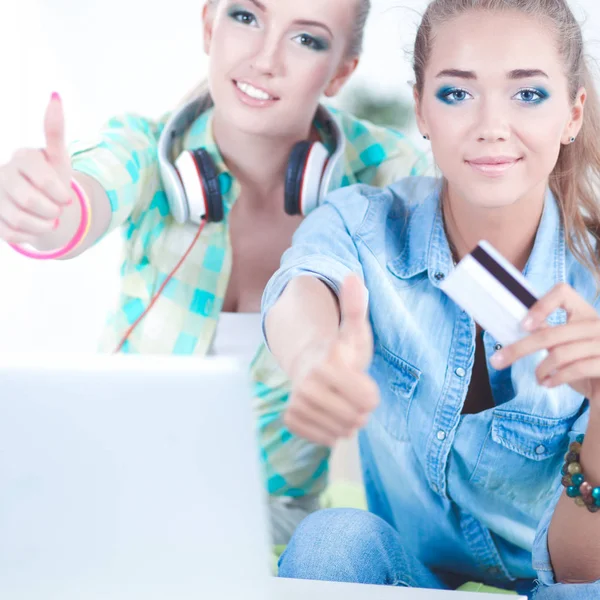 Dwóch młodych kobiet siedzi z laptopa i kredytowego koszyka w domu — Zdjęcie stockowe