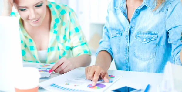 Two women working together at office, sitting on the desk — Stock Photo, Image