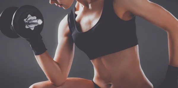 Mujer atlética bombeando músculos con mancuernas — Foto de Stock