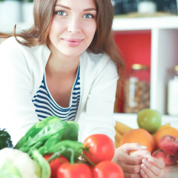 Jonge vrouw zit in de buurt van bureau in de keuken — Stockfoto