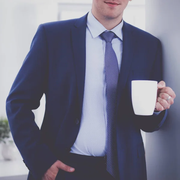 Empresário sorridente de pé com xícara de café — Fotografia de Stock