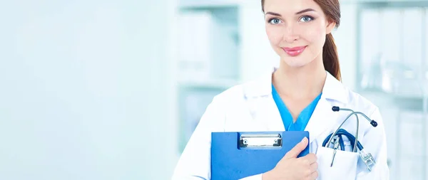 Lächelnde Ärztin mit Ordner in Uniform steht im Krankenhaus — Stockfoto