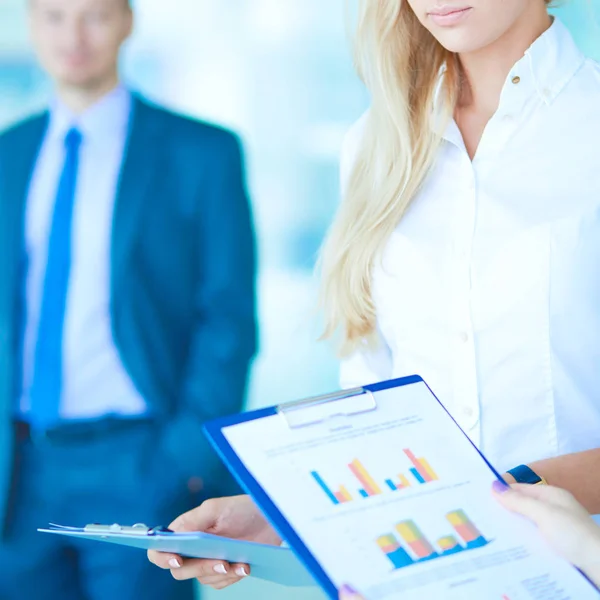 Portrait of young businesswoman in office with colleagues in the background — Stock Photo, Image