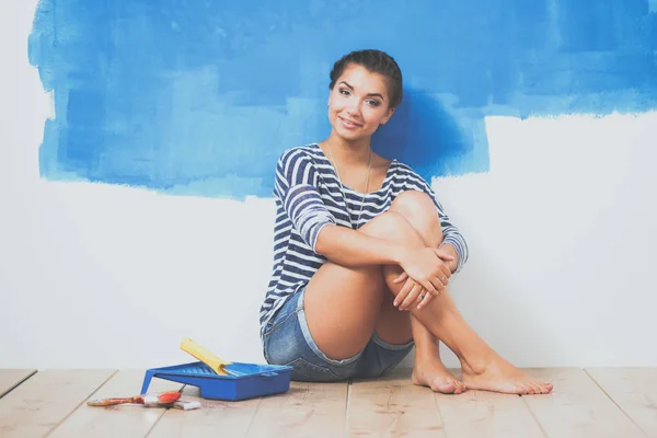 Retrato de pintora sentada en el suelo cerca de la pared después de pintar —  Fotos de Stock