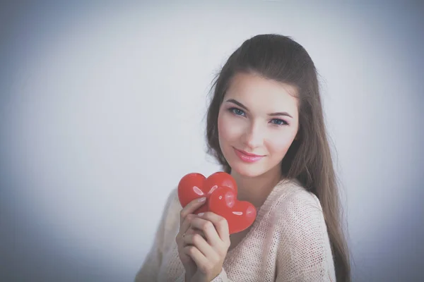 Belle femme tenir rouge entendre, isolé sur fond gris — Photo