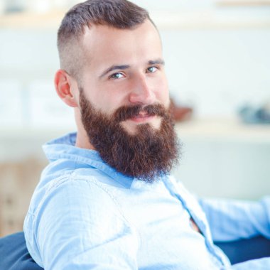 Genç işadamı koltukta oturuyor.